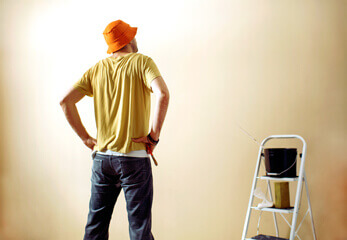 ein Mann beim Renvieren einer Wand